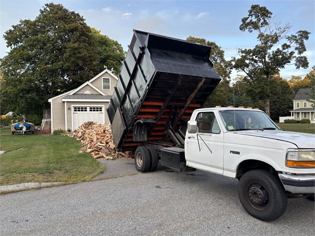 Liberty dump truck unloading wood at a customer's home